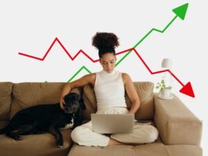Best Investment Platforms for Global Investors: A woman sitting on a couch with a laptop, analyzing market trends while her dog rests beside her