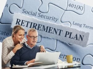 A middle-aged couple reviewing their retirement plan on a laptop with a puzzle background featuring Social Security and 401(k).