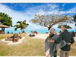 A retired couple walking along a tropical beach, enjoying their retirement life.