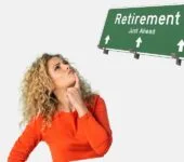 woman in an orange sweater thinking about retirement with a road sign that reads "Retirement Just Ahead."