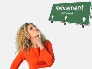 woman in an orange sweater thinking about retirement with a road sign that reads "Retirement Just Ahead."