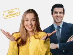 A smiling woman in a yellow sweater stands with a confident businessman behind her, and a “Loan Approved” stamp is visible