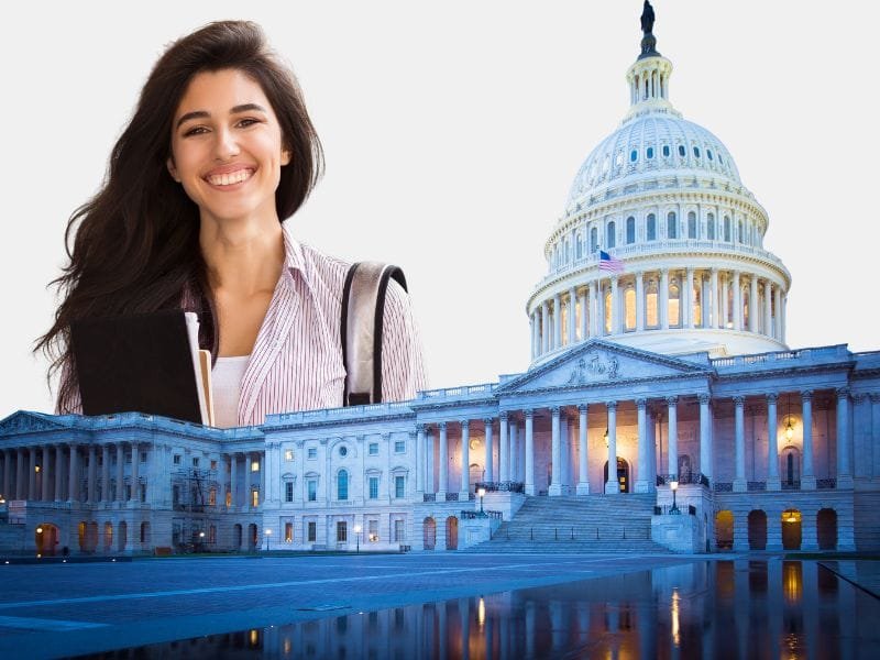 A smiling student holding books and a backpack, standing in front of the U.S. Capitol, representing student loan forgiveness opportunities in the U.S.